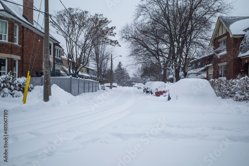 Toronto, Ontario / Canada - January 17, 2022 - Toronto St Clair West sideroad with cars covered on day of snowstorm © JW