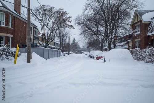 Toronto, Ontario / Canada - January 17, 2022 - Toronto St Clair West sideroad with cars covered on day of snowstorm