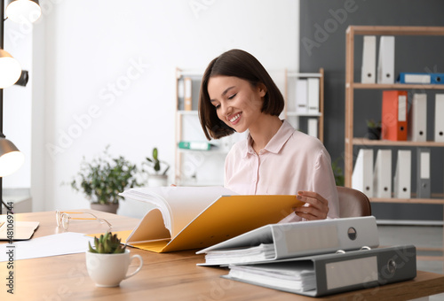 Young woman working with documents in office