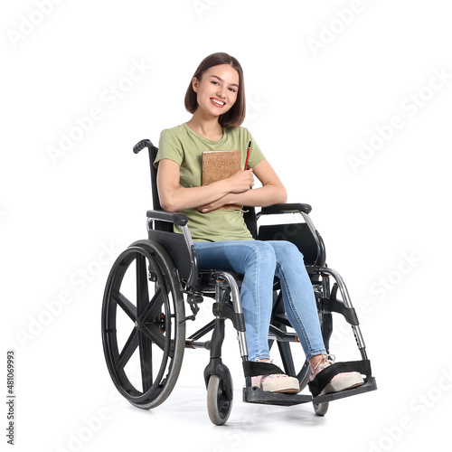 Young woman in wheelchair and with notebook on white background © Pixel-Shot