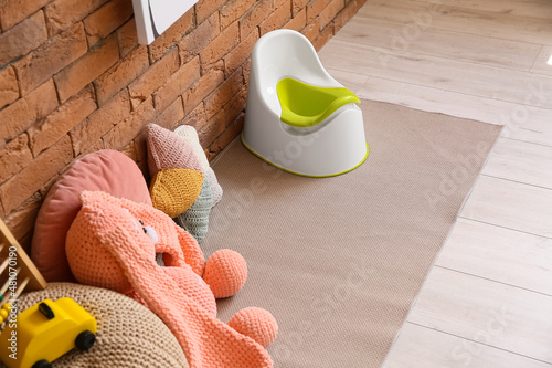 Potty and toys on floor nea...