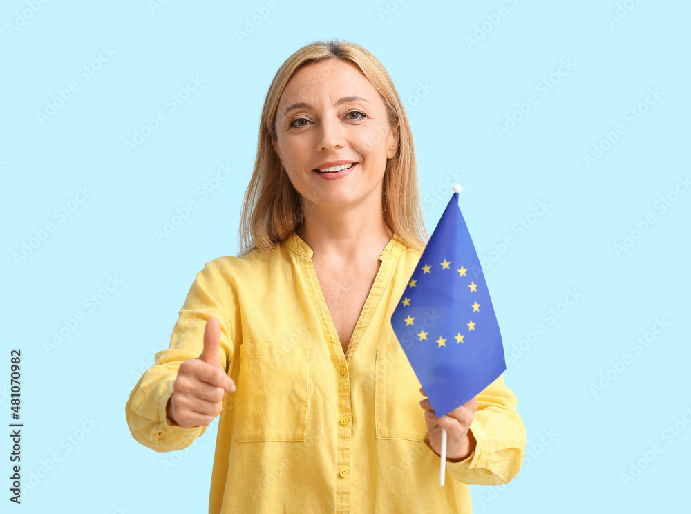Mature woman with flag of European Union showing thumb-up on color background Mature woman with flag of European Union showing thumb-up on color background
