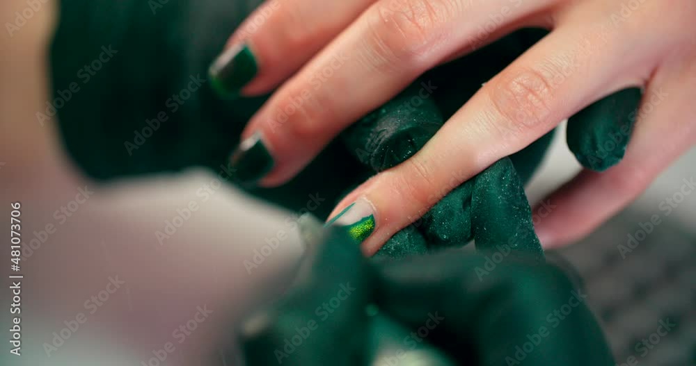 A manicurist grinds nails with a manicure machine. A manicurist grinds nails with a manicure machine.
