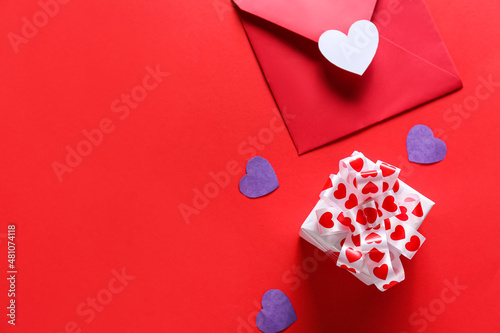 Gift for Valentine day, envelope and hearts on red background
