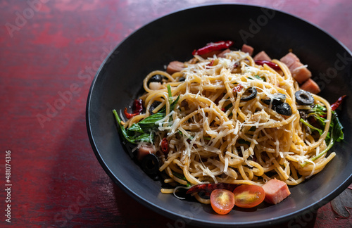 Spaghetti with chili paste and ham served on red table. Spaghetti is one of the most popular forms of pasta, and it's used in dishes all around the world, is fairly neutral, diet.