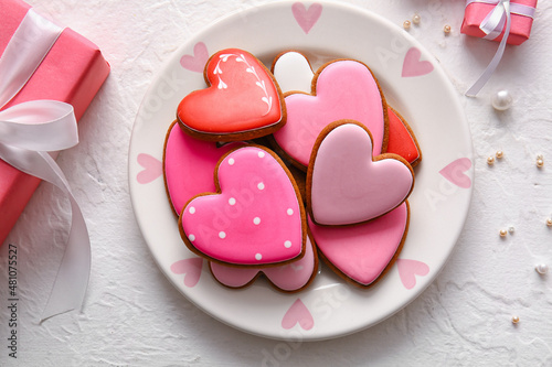 Plate with tasty heart shaped cookies on white background