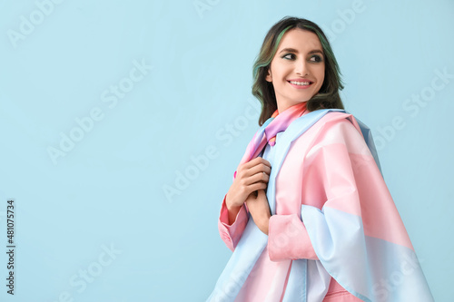 Beautiful young woman with unusual hair and transgender flag on color background photo