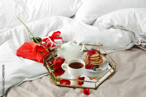 Tray with tasty breakfast  rose flower and gift boxes for Valentine s Day on bed