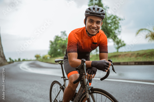 happy smiling road bike cyclist while riding his bike outdoor © Odua Images