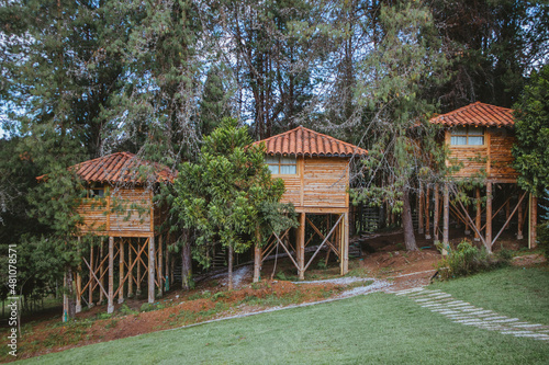 Una casa hecha de elementos de madera a lado de los arboles.