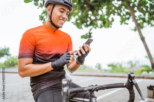 road bike cyclist sitting on his bike while using mobile phone © Odua Images