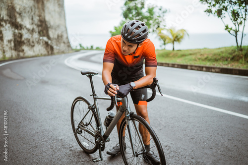 tired cyclist while riding his bike outdoor © Odua Images
