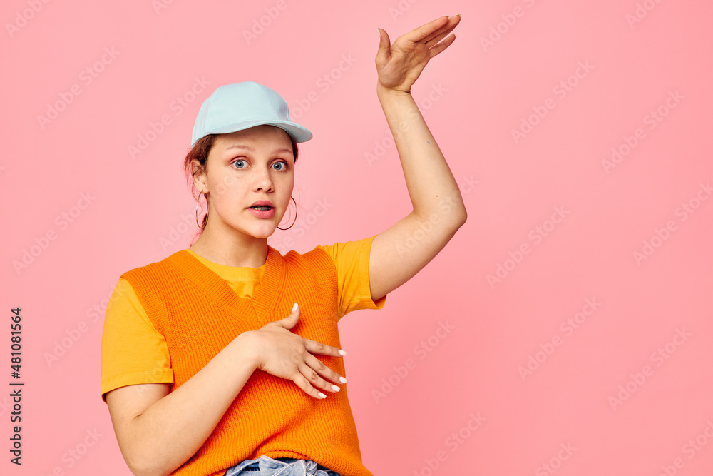 funny girl in an orange sweater in blue caps hand gesture Lifestyle unaltered funny girl in an orange sweater in blue caps hand gesture Lifestyle unaltered