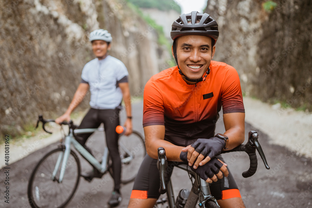 Obraz premium man with his friend riding a road bike together in the country road