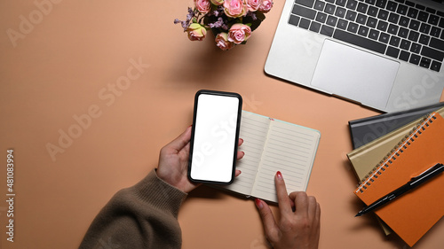 Overhead view woman holding smart phone with white empty screen. © Prathankarnpap