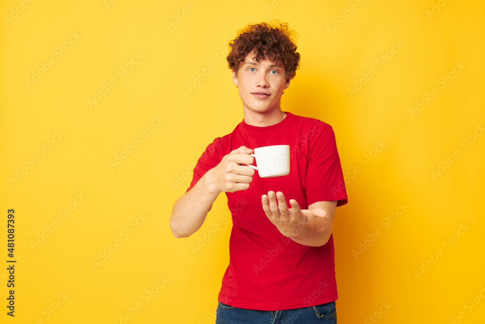 guy with red curly hair white mug in the hands of a drink yellow background unaltered guy with red curly hair white mug in the hands of a drink yellow background unaltered