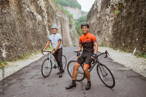 man with his friend riding a road bike together in the country road