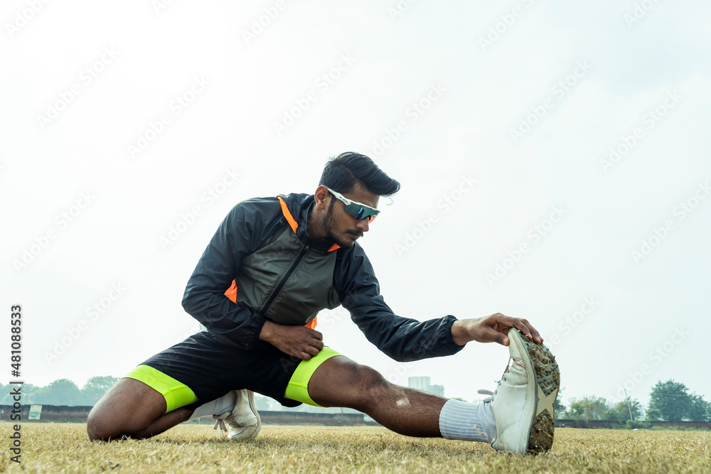 Young sportsman working out in the playground. player getting ready before a match and stretching his body. Sports and healthy lifestyle concept. Young sportsman working out in the playground. player getting ready before a match and stretching his body. Sports and healthy lifestyle concept.