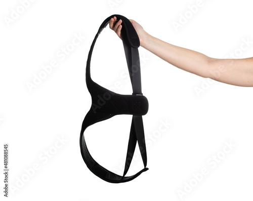 Medical posture corrector in hand on a white background. Back pain treatment concept, isolate. Rehabilitation spine photo