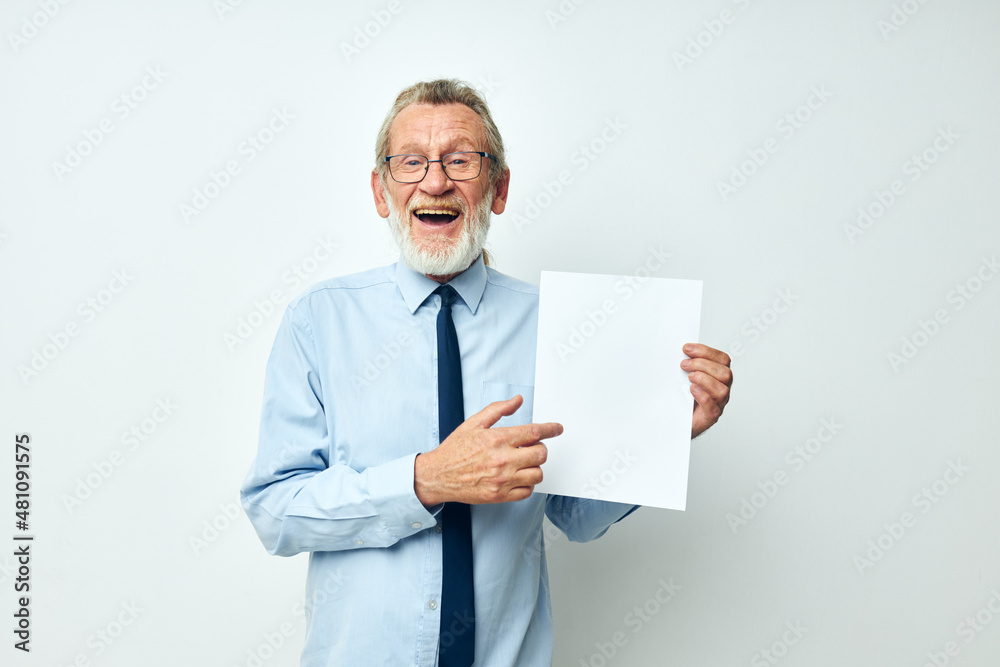 Portrait of happy senior man holding documents with a sheet of paper light background Portrait of happy senior man holding documents with a sheet of paper light background
