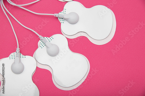 Electrical electrodes for stimulating the patient's body on a pink background. Acupuncture massager photo