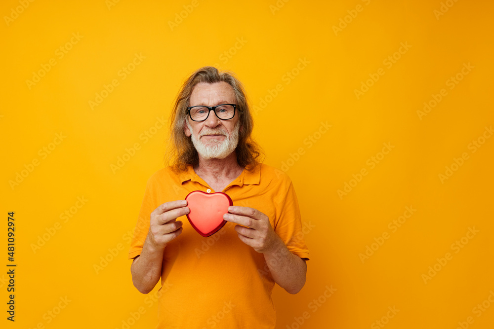 Senior grey-haired man red heart gift emotions yellow glasses cropped view Senior grey-haired man red heart gift emotions yellow glasses cropped view