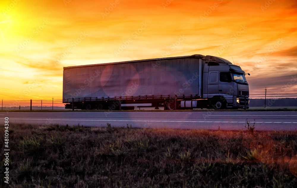 A beautiful truck with a trailer against the backdrop of an evening sunset before night. The concept of work and rest regime for truck drivers. Fine for breaching rules A beautiful truck with a trailer against the backdrop of an evening sunset before night. The concept of work and rest regime for truck drivers. Fine for breaching rules