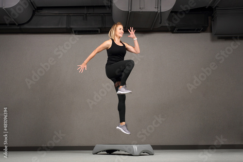  Stepp jump, step fitness. Sports training, a young attractive woman is exercising in a class at a fitness club © Robert Przybysz