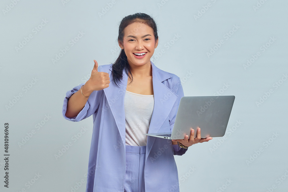 Portrait of beautiful Asian woman using laptop smiling and showing thumbs up over white background Portrait of beautiful Asian woman using laptop smiling and showing thumbs up over white background