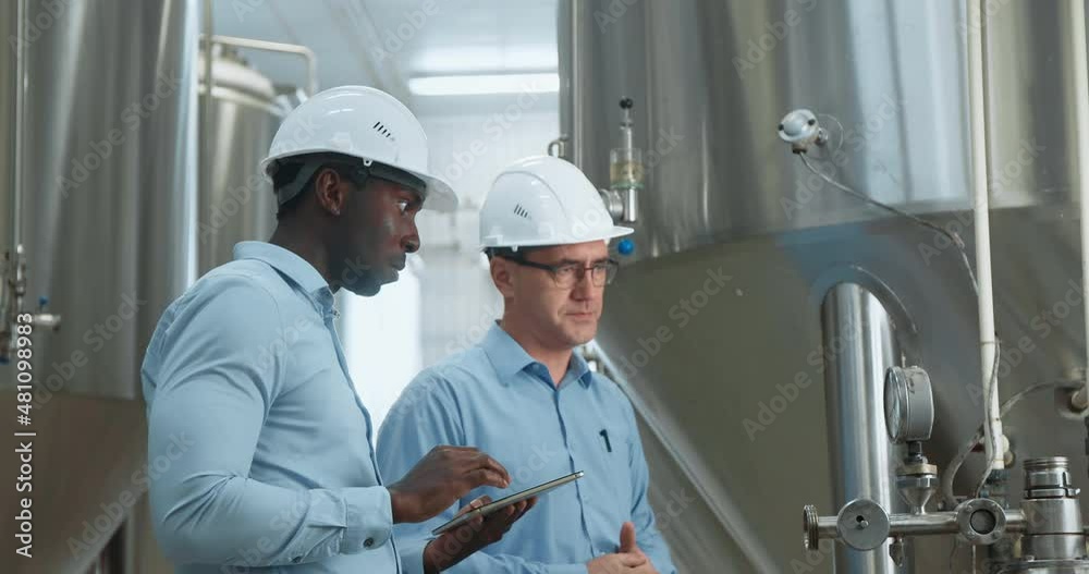 Two Industry Engineers Walk in Factory, Use Tablet and Discuss Work