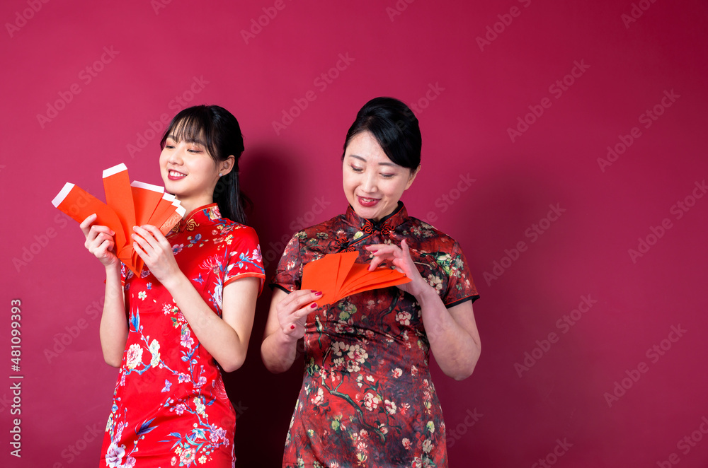 Asian mother and daughter holding red envelopes Asian mother and daughter holding red envelopes