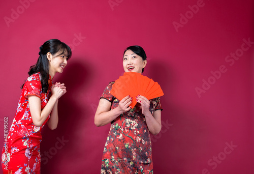 Asian mother and daughter holding red envelopes