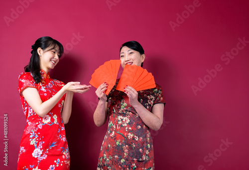 Asian mother and daughter holding red envelopes