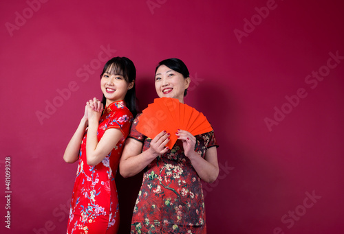 Asian mother and daughter holding red envelopes