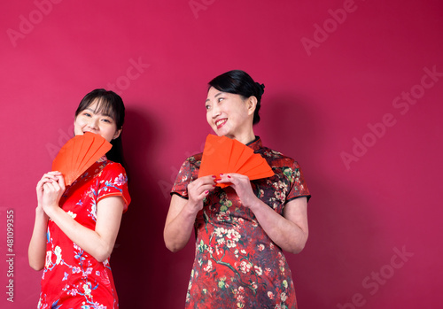 Asian mother and daughter holding red envelopes