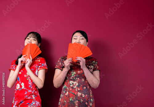 Asian mother and daughter holding red envelopes