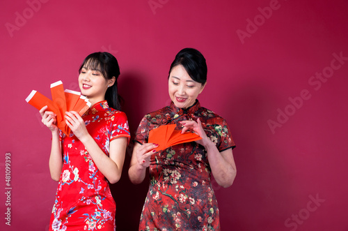 Asian mother and daughter holding red envelopes