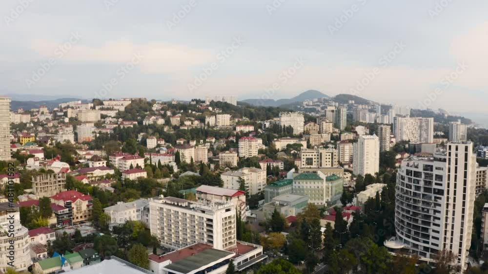 Picturesque industrial city. You can see high-rise buildings, where there are many green areas of trees, cars are passing by. Mountains in the distance Picturesque industrial city. You can see high-rise buildings, where there are many green areas of trees, cars are passing by. Mountains in the distance