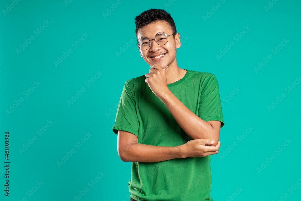 portrait of smiling handsome young man in casual t-shirt, isolated on green background