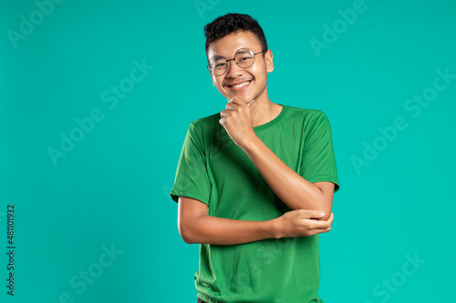 Obraz na płótnie portrait of smiling handsome young man in casual t-shirt, isolated on green background w salonie