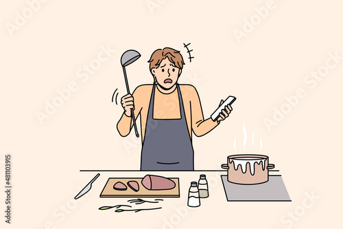 Cooking and preparing food concept. Young confused man in apron standing trying to cook soup boiling and holding smartphone with recipe in hand vector illustration 