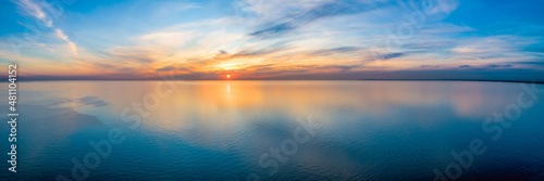 Wide aerial panorama of seascape - sunset reflecting in calm sea photo