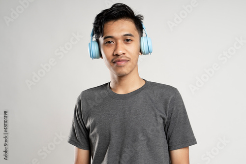 Happy young man posing with headphones on white.