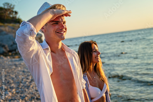 Attractive young couple on the beach, enjoying summer vacation, travel