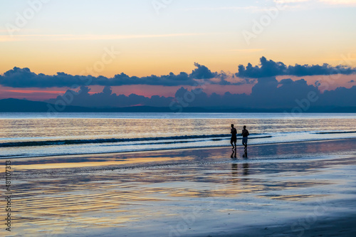 couple on the beach at sunset photo