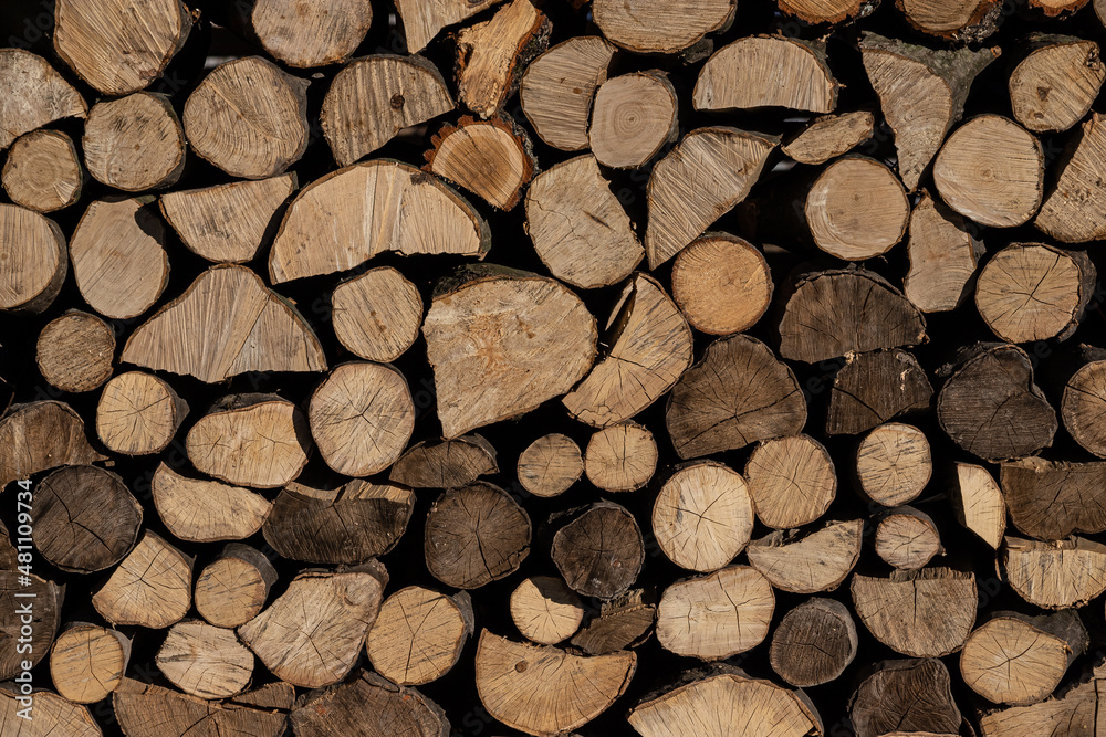 Pile of stacked triangle firewood prepared for fireplace and boiler Pile of stacked triangle firewood prepared for fireplace and boiler