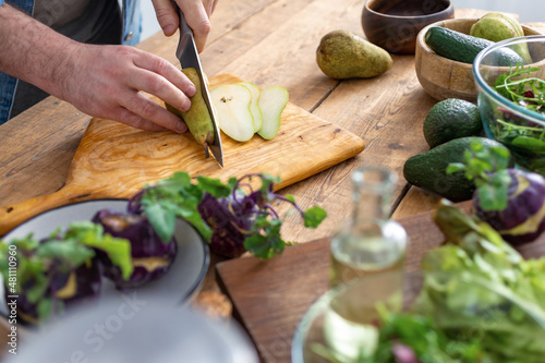 Cooking healthy and tasty breakfast or lunch. Male hands preparing vegetarian food at home kitchen