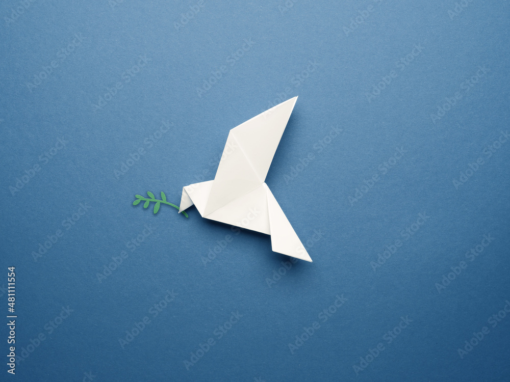 White origami pigeon on a blue paper background, peace or freedom concept - obrazy, fototapety, plakaty 