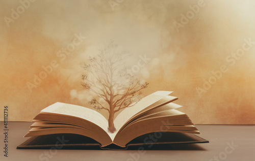The tree of knowledge , a tree growing from the pages of an open book , fantasy image concept of knowledge and wisdom