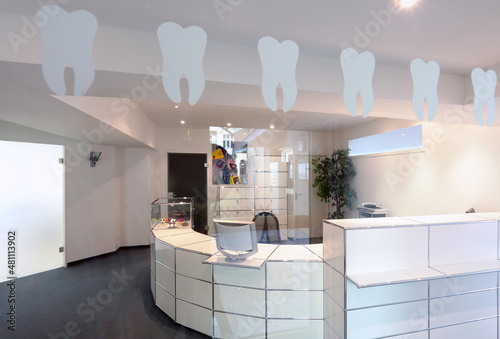 Empfangsbereich einer Zahnarztpraxis- Duerchblick durch eine mit Zähnen beklebte Glastür